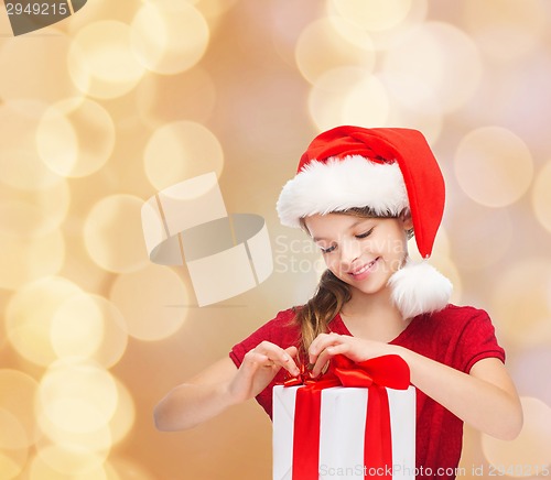 Image of smiling girl in santa helper hat with gift box