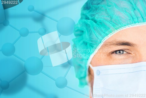 Image of close up of surgeon in medical cap and mask