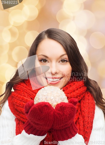 Image of smiling woman in winter clothes with snowball