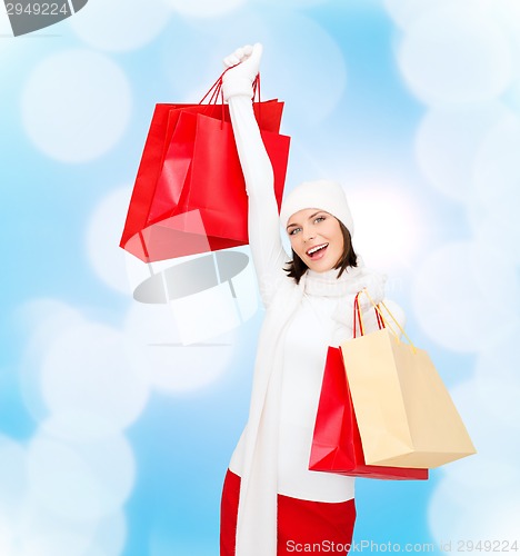 Image of smiling young woman with red shopping bags
