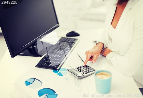 Image of woman hand with calculator and papers