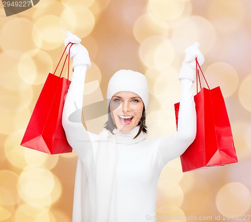 Image of smiling young woman with red shopping bags