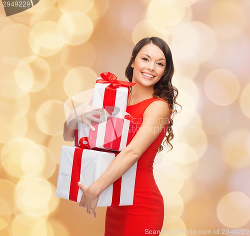 Image of smiling woman in red dress with gift boxes