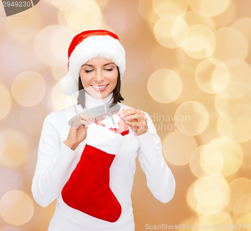 Image of woman in santa hat with gift box and stocking