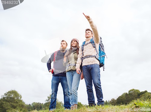 Image of group of smiling friends with backpacks hiking