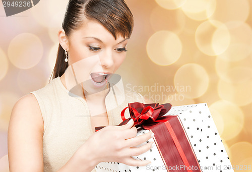 Image of smiling woman in red dress with gift box