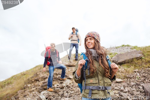 Image of group of smiling friends with backpacks hiking