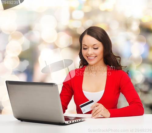 Image of smiling woman with credit card and laptop