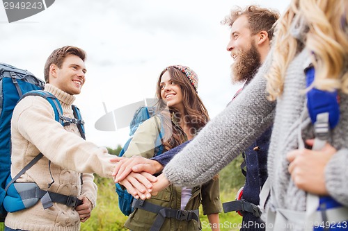 Image of group of smiling friends with backpacks hiking