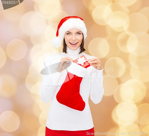 Image of woman in santa hat with gift box and stocking