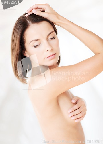 Image of woman checking breast for signs of cancer