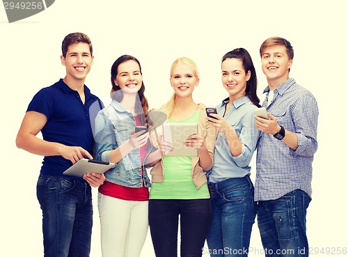 Image of smiling students using smartphones and tablet pc