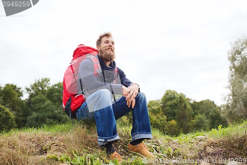 Image of smiling man with backpack hiking