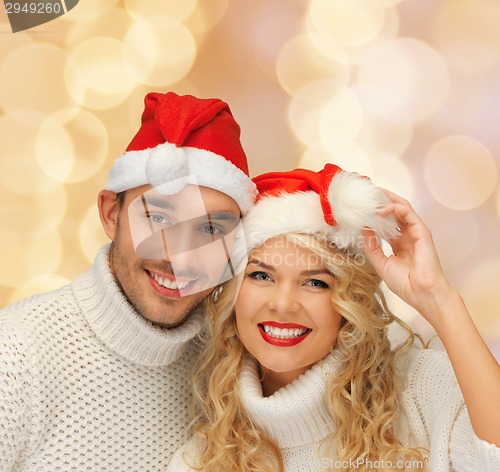 Image of smiling couple in sweaters and santa helper hats