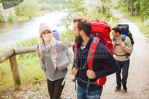 Image of group of smiling friends with backpacks hiking