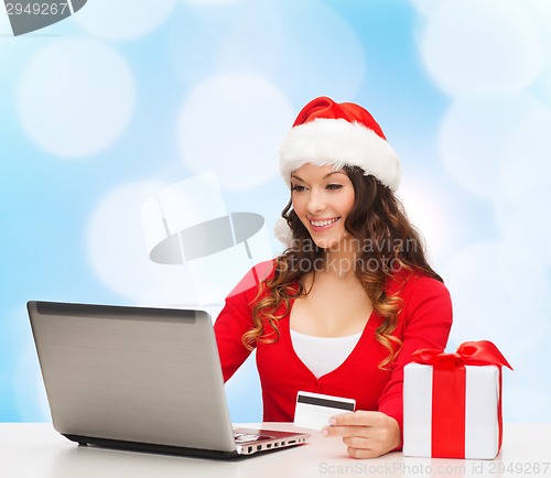 Image of smiling woman with credit card and laptop