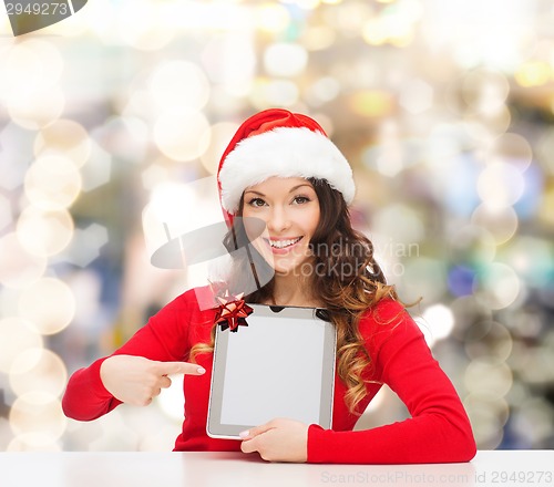 Image of smiling woman in santa hat with gift and tablet pc