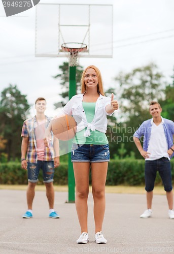 Image of group of smiling teenagers playing basketball