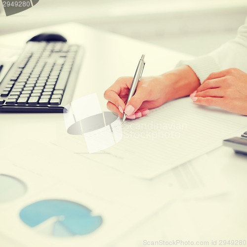 Image of businesswoman working with calculator in office