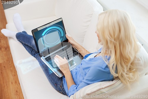 Image of smiling woman with laptop computer at home