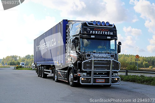 Image of Black Scania Truck Hauls Container