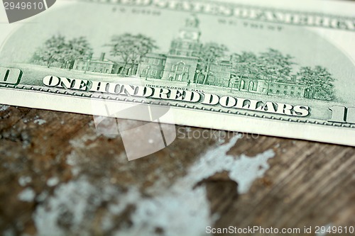 Image of Close-up of a $100 banknotes on wooden background