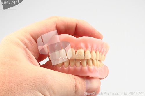 Image of teeth prosthesis in the human hand 