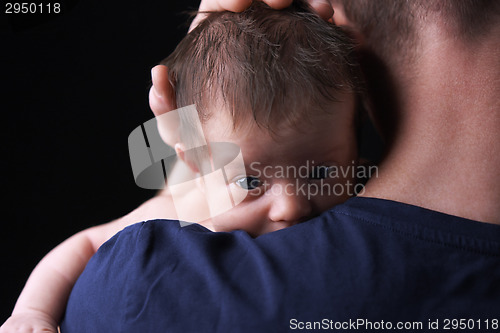 Image of Newborn baby lying on the father's shoulder