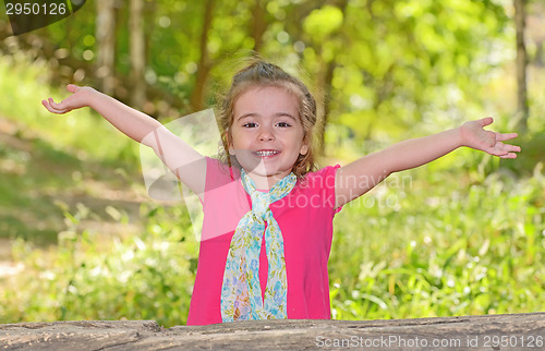 Image of little girl enjoying and raising her hands 