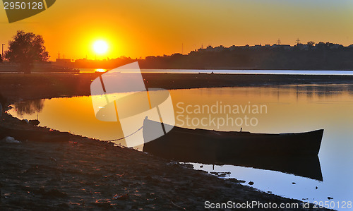 Image of  fishing boat with sunrise in the background