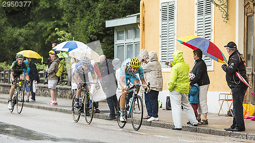 Image of Three Cyclists Riding in the Rain