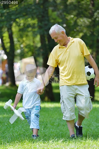 Image of happy grandfather and child in park