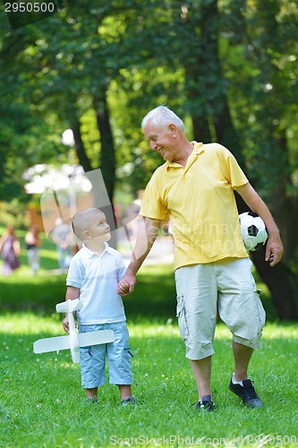 Image of happy grandfather and child in park