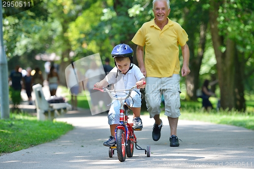 Image of happy grandfather and child in park