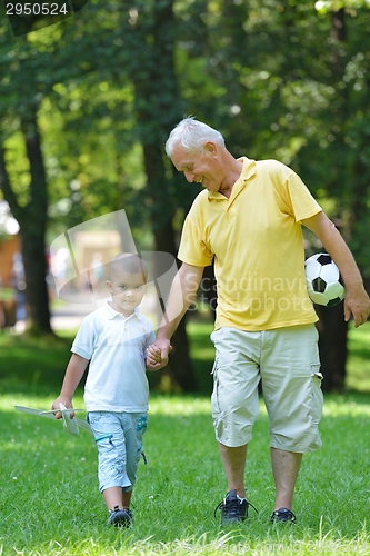 Image of happy grandfather and child in park