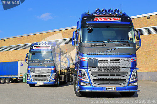 Image of Two New Volvo FH Tanker Trucks by a Warehouse