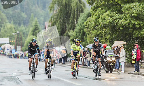 Image of Four Cyclists Riding in the Rain