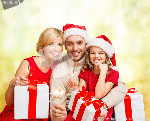 Image of smiling family holding gift boxes and sparkles