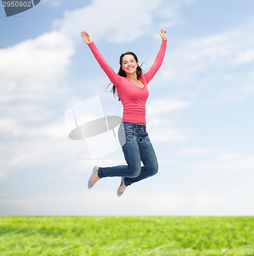 Image of smiling young woman jumping in air