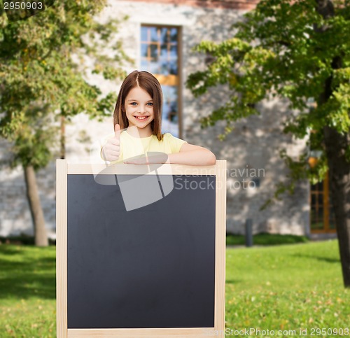 Image of happy little girl with blank blackboard