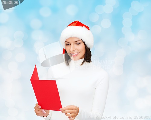 Image of smiling woman in santa hat with greeting card