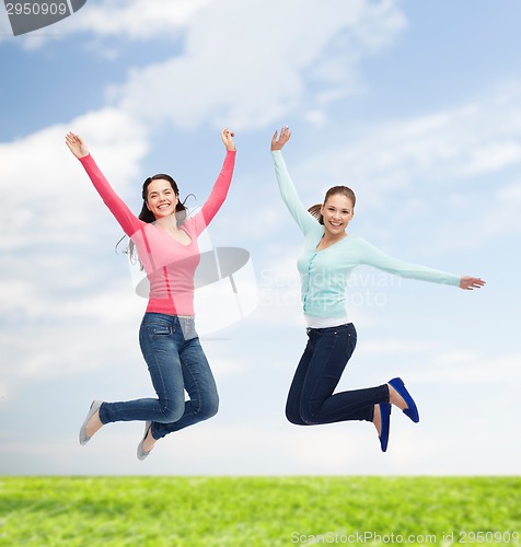 Image of smiling young women jumping in air