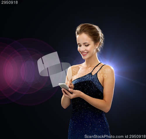 Image of smiling woman in evening dress with smartphone