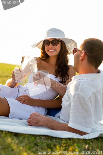 Image of smiling couple drinking champagne on picnic
