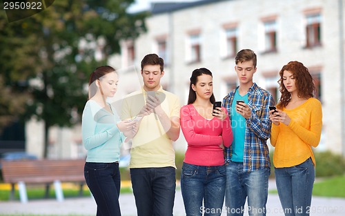 Image of group of serious teenagers with smartphones