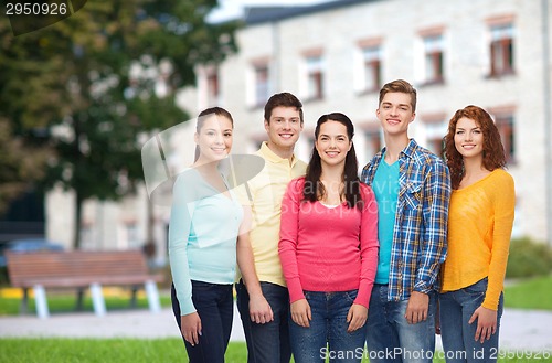 Image of group of smiling teenagers over campus background