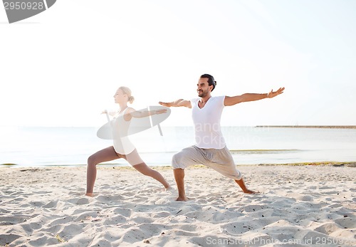 Image of couple making yoga exercises outdoors