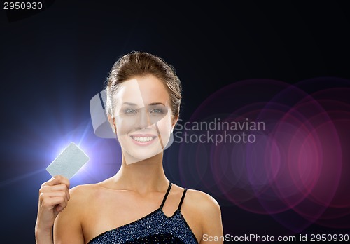 Image of smiling woman in evening dress holding credit card