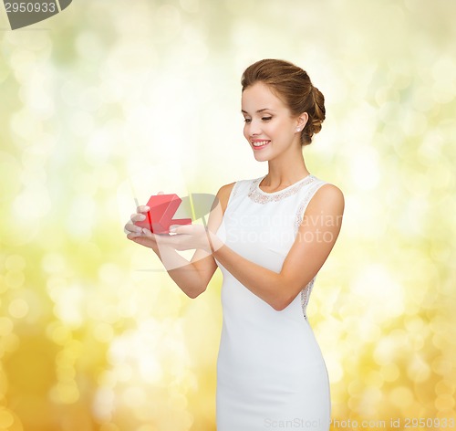 Image of smiling woman holding red gift box