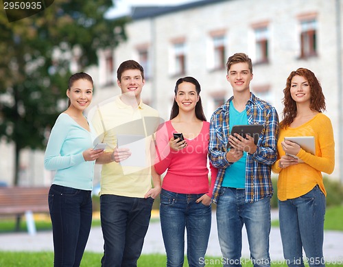 Image of group of teenagers with smartphones and tablet pc